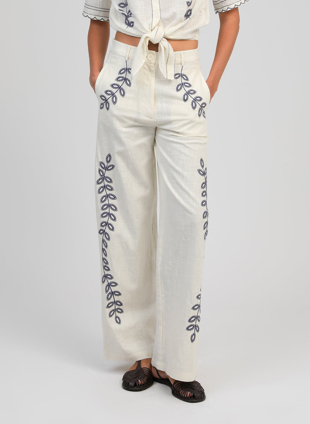 An'ge – Pantalon Rossalie Ecru, pantalon large blanc cassé brodé de motifs végétaux bleus, porté de face