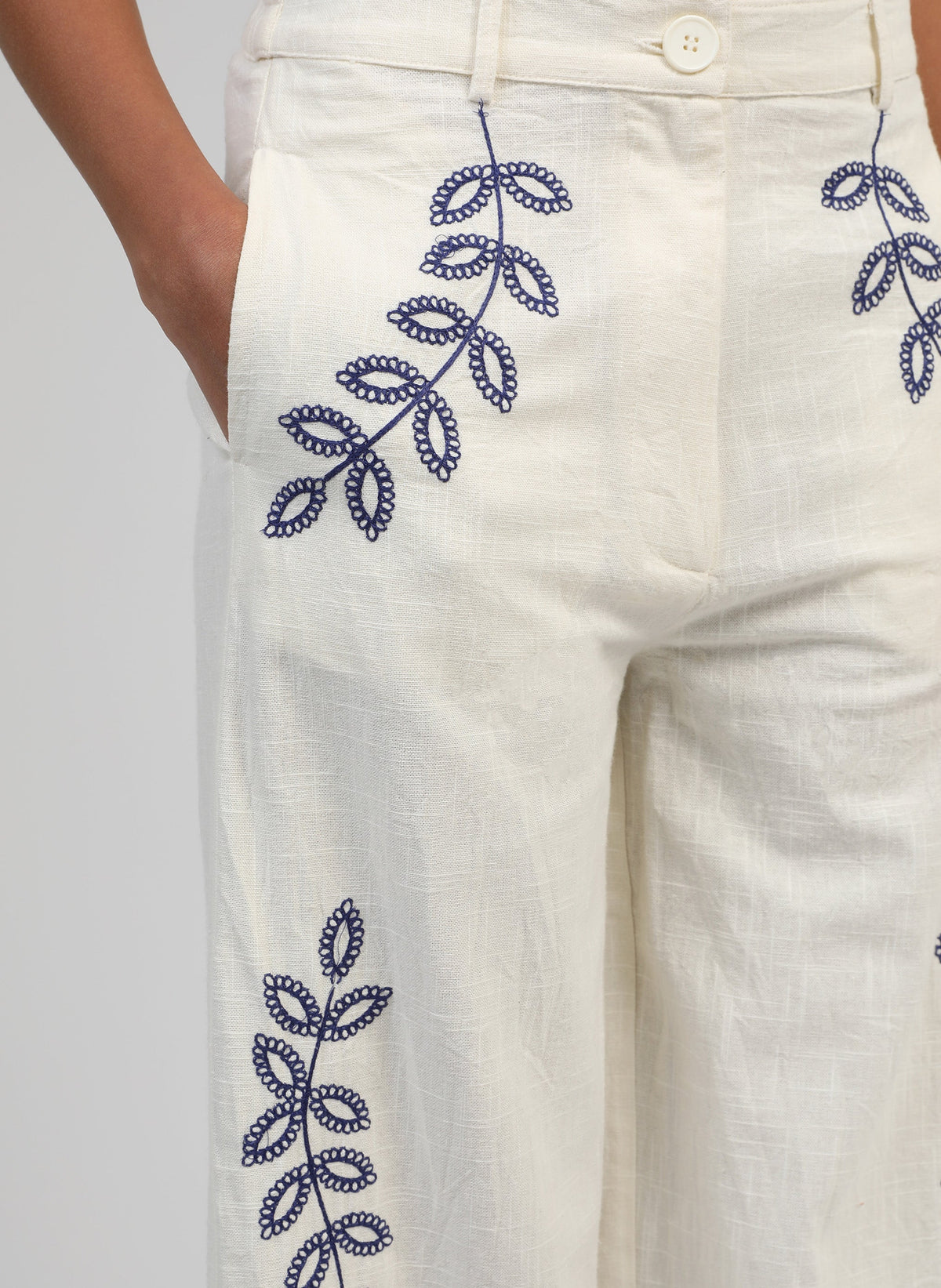 An'ge – Pantalon Rossalie Ecru, pantalon blanc cassé brodé de motifs végétaux bleus, porté par un mannequin