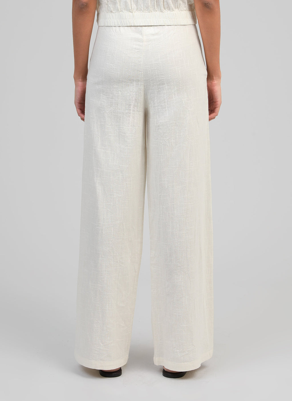 An'ge – Pantalon Rossalie Ecru, pantalon large en lin blanc cassé porté de dos par un mannequin