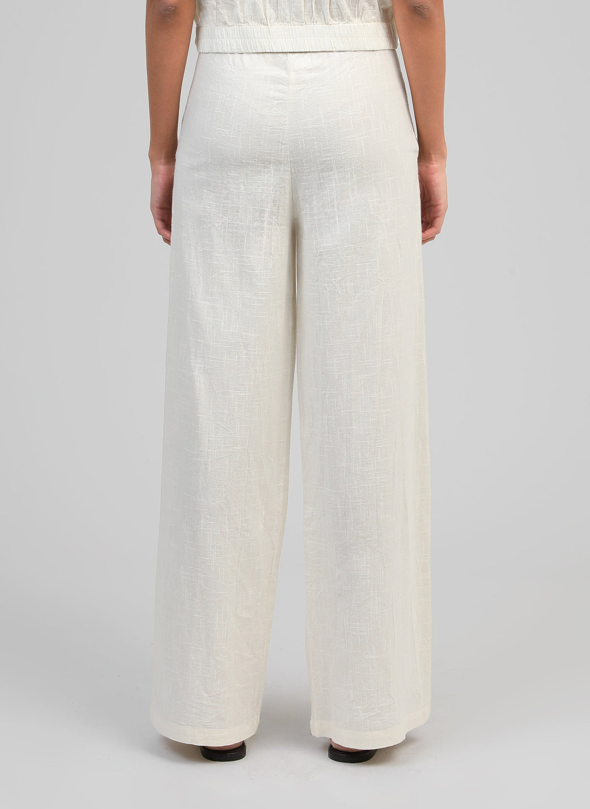 An'ge – Pantalon Rossalie Ecru, pantalon large en lin blanc cassé porté de dos par un mannequin