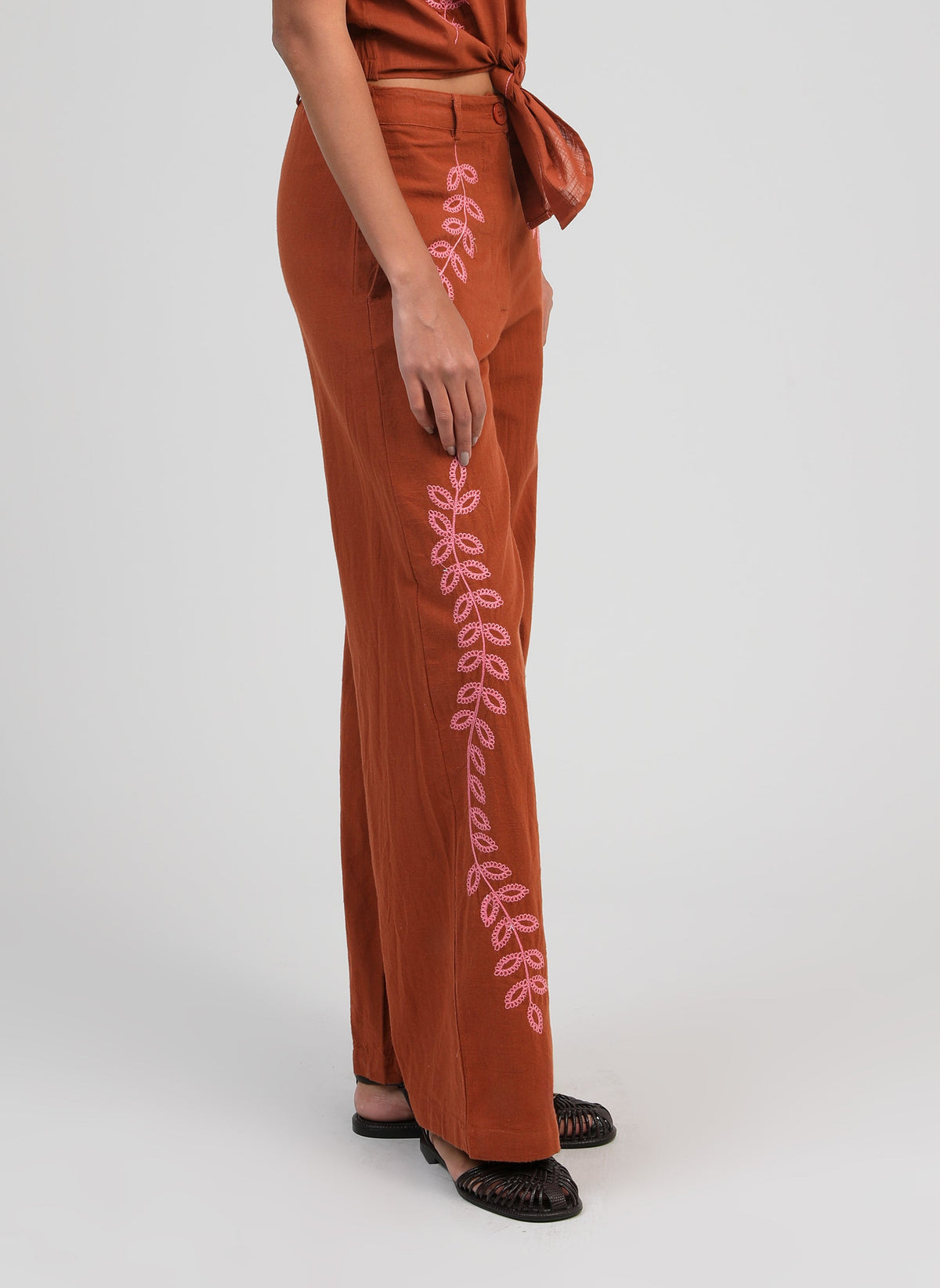 An'ge – Hose Rossalie Caramel, weite braune Hose mit rosa Stickereien, von der Seite getragen