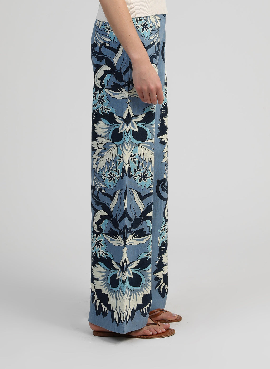 An'ge – Pantalon Rossini Pachama Bleu, blauwe wijde broek met print gedragen door een model, van opzij gezien