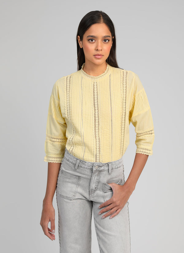 An'ge – Blouse Samilou Jaune, model iført en lysegul bluse og grå jeans
