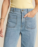 Vaqueros de mujer en denim 100% algodón de color azul claro con cómodo corte recto y bolsillos de parche delanteros, ideales para un estilo casual y moderno.