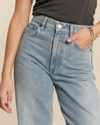 Jean en denim clair stone bleach avec coupe droite et taille haute, matière en coton douce adaptée pour femme, offrant un style estival et décontracté.