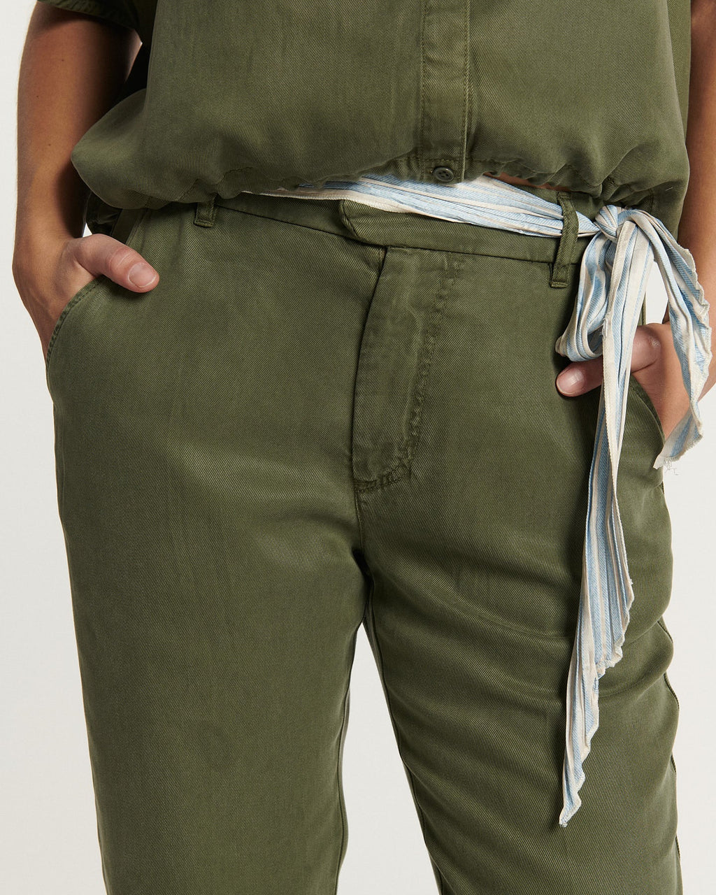 Women's pants in khaki tencel fabric, fitted straight cut with striped knotted belt, fluid and comfortable material suitable for all body shapes.