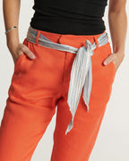 Pantalon femme en Tencel orange tangerine, coupe droite confortable avec une taille haute et une ceinture rayée en tissu léger, matière douce et fluide.