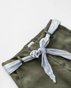 Women's pants in khaki Tencel fabric, fitted straight cut with tied belt in light blue and white striped fabric, casual and comfortable style.