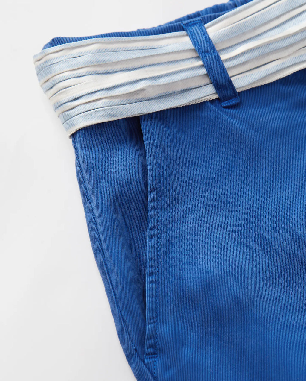 Jean femme en tissu tencel bleu outre-mer, coupe droite ajustée avec texture douce et ceinture rayée blanche et bleue pour une touche estivale élégante.