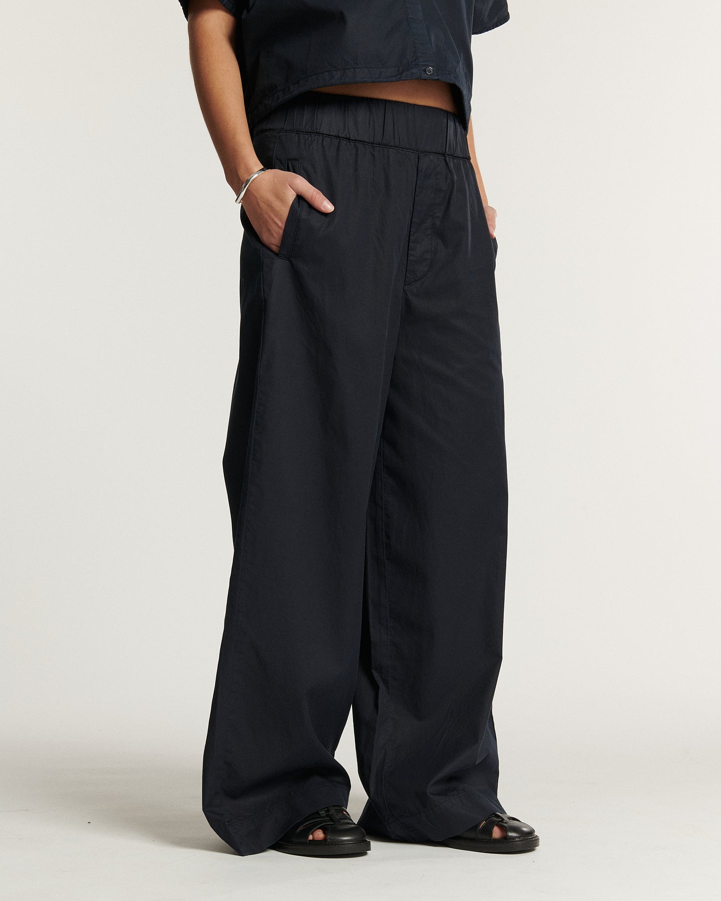 Pantalon large en popeline navy, coupe fluide avec taille élastique, matière légère et confortable adaptée pour l’été, style décontracté pour femme.