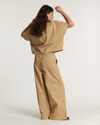 Pantalón ancho de popelina color praliné, ligero y fluido, de corte holgado perfecto para adaptarse a todas las morfologías femeninas con elegancia y comodidad.