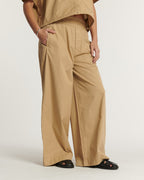 Pantalón ancho en popelín color praliné, material ligero y fluido, corte relajado con cintura elástica, perfecto para un estilo veraniego femenino y cómodo.