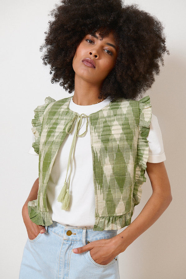 Chaqueta caqui sin mangas en tejido ikat, lazo con pompón en el cuello y volantes para un toque bohemio