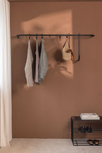 Moderne Garderobe TAMINA mit minimalistischer Aufhängung für Kleidung und Accessoires an einer Wand.