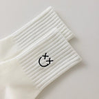 Chaussettes blanches montantes avec smiley, confortables et stylées, idéales avec des baskets. Coton épais, look tendance et maintien optimal.