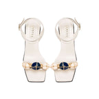 Delphine 50MM Ankle Cross Sandal in ivory with aqua beads and wide straps, blending nature-inspired colors.