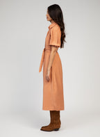 An'ge – Malida Maxi Dress Terracotta, model wearing a peach-coloured midi shirt dress, side view
