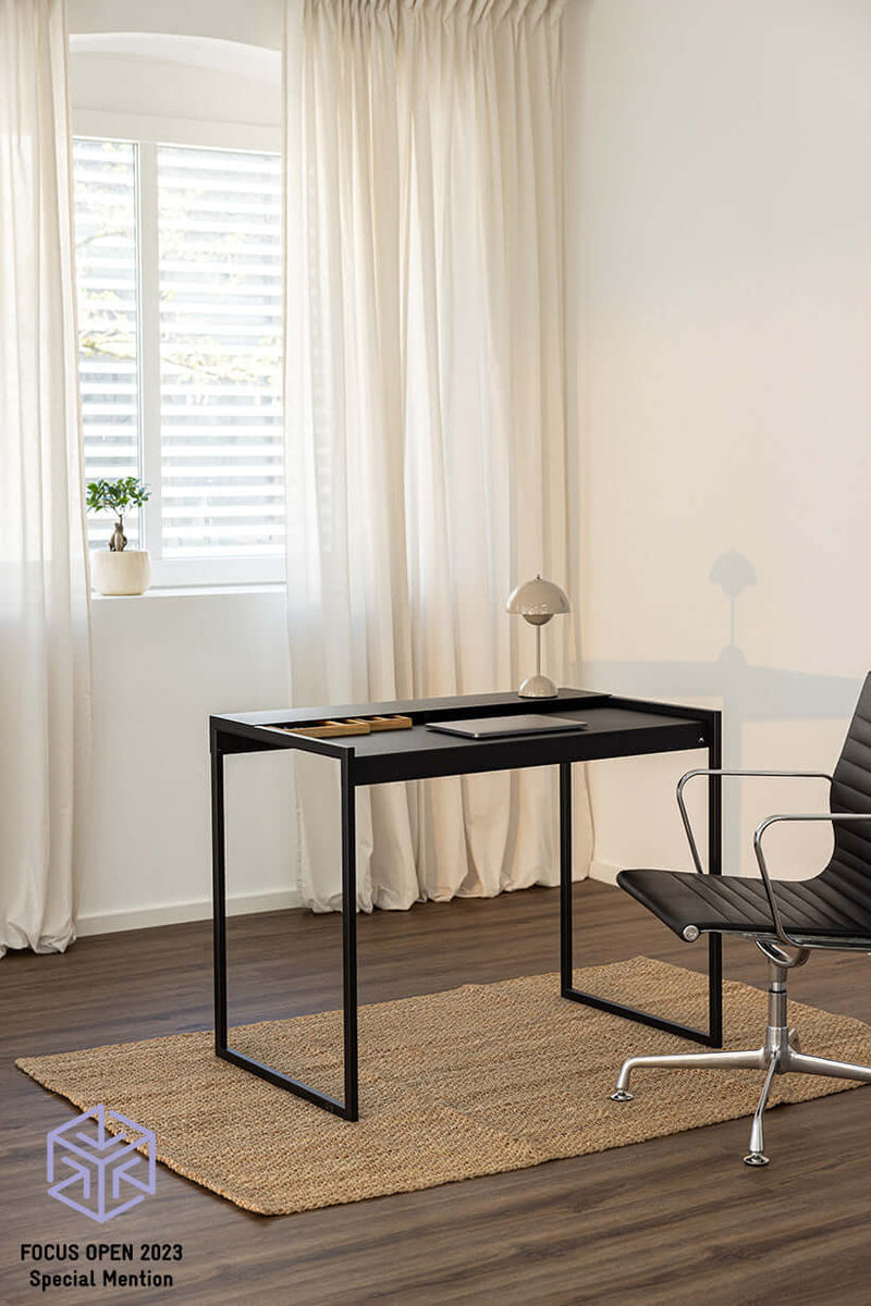 Schreibtisch DONNA en el moderno Raum mit Stuhl und Teppich, diseño minimalista en Schwarz.