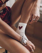 Calcetines de color blanco roto con estampado de corazones: un accesorio romántico para estar en casa