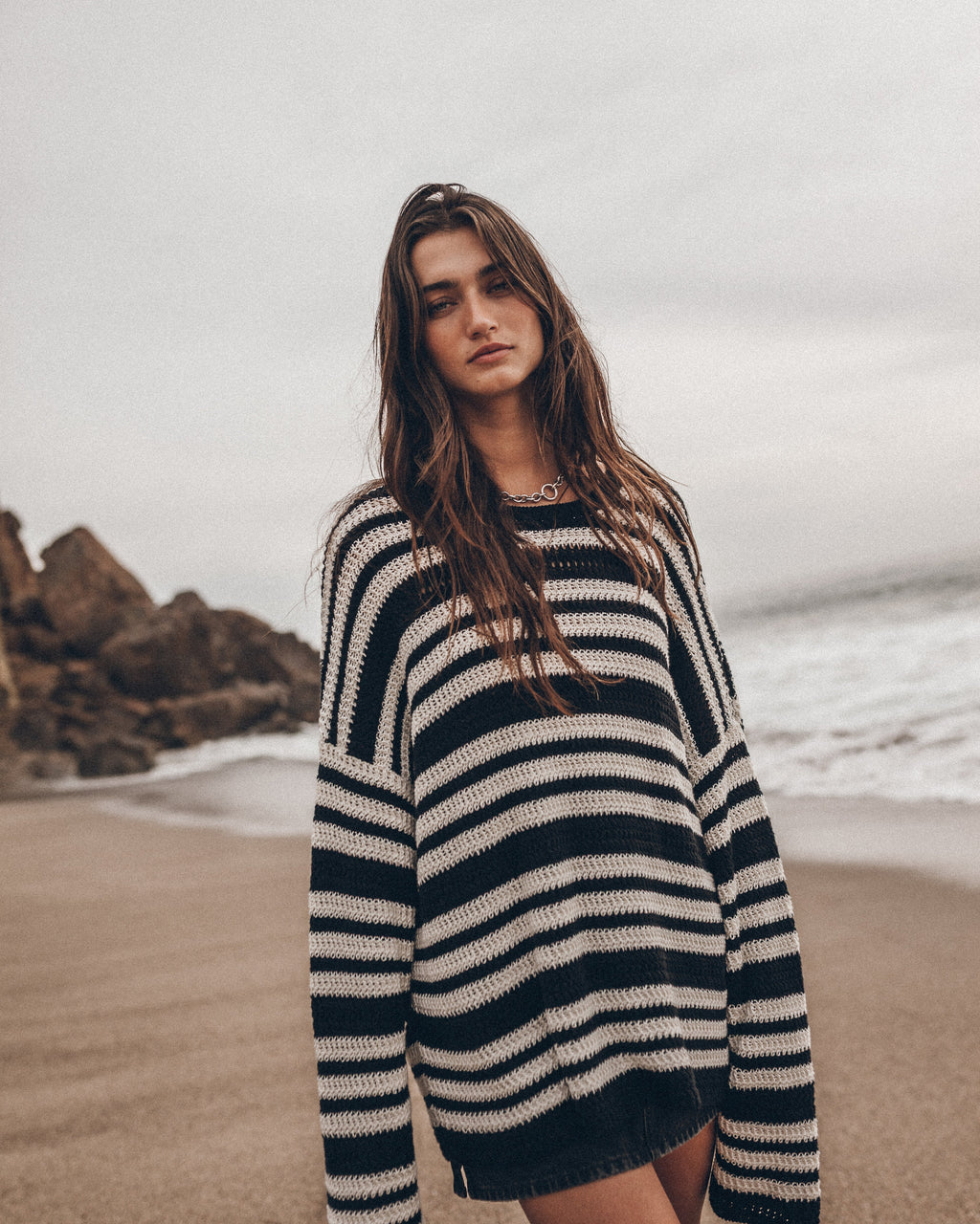 Mujer vistiendo un suéter a rayas en la playa