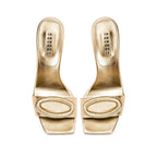 Naria Gold High-Heel Sandal featuring elegant gold leather and intricate oval embellishments.