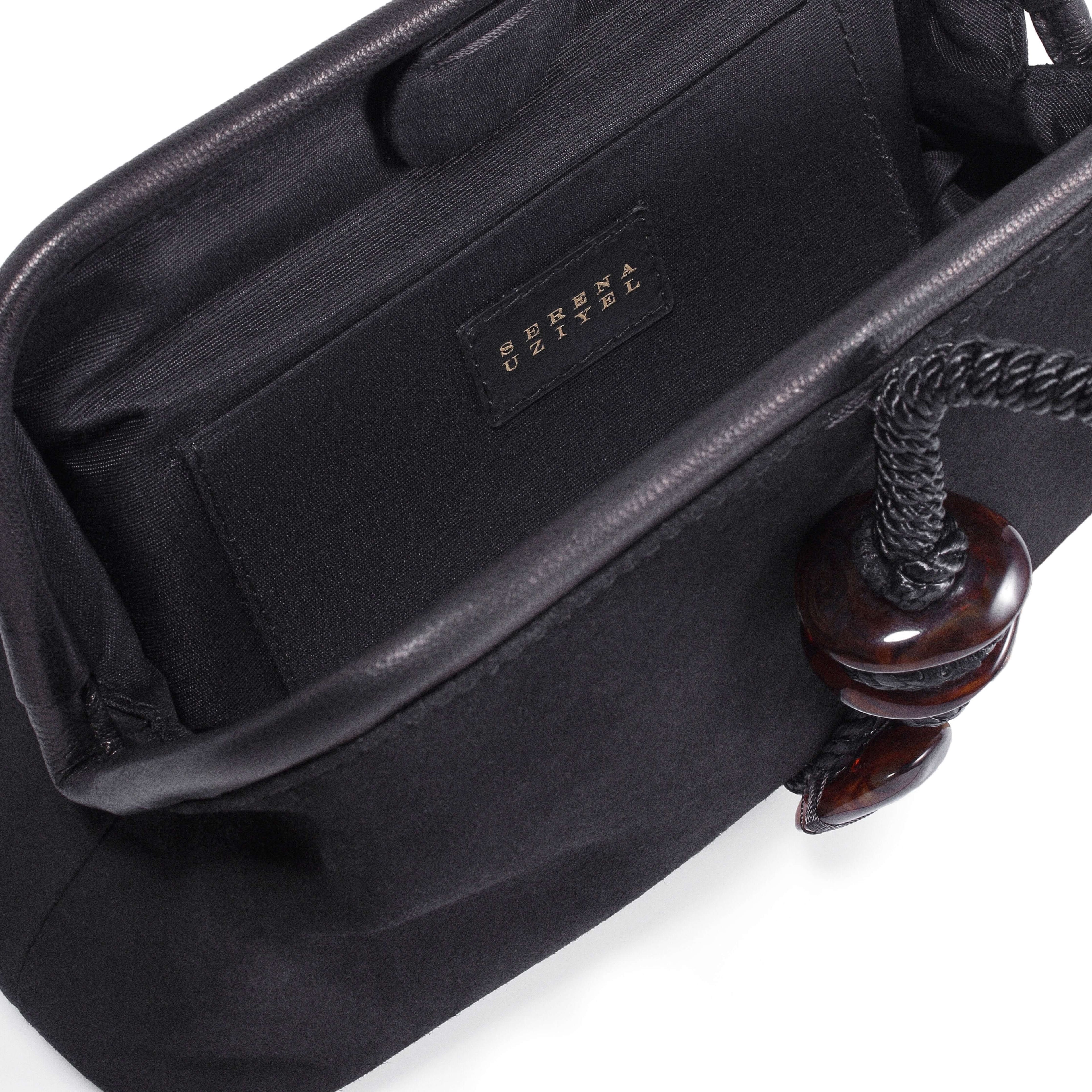 Inside view of the Petra Black Pouch Bag, featuring a suede leather interior and stylish detail.