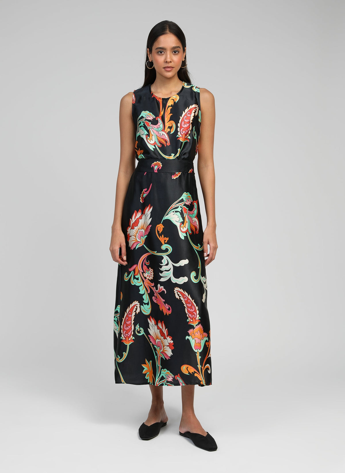 An'ge – Jupe Midi Robilou Indina Noir, model wearing a black dress with colourful floral patterns, front view