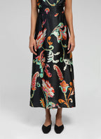 An'ge – Jupe Midi Robilou Indina Noir, long black dress with colourful floral patterns worn by a model