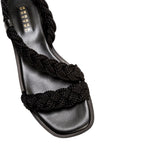 Ronda Black Flat Asymmetric Sandal featuring braided black straps and a sleek leather sole, perfect for summer wear.