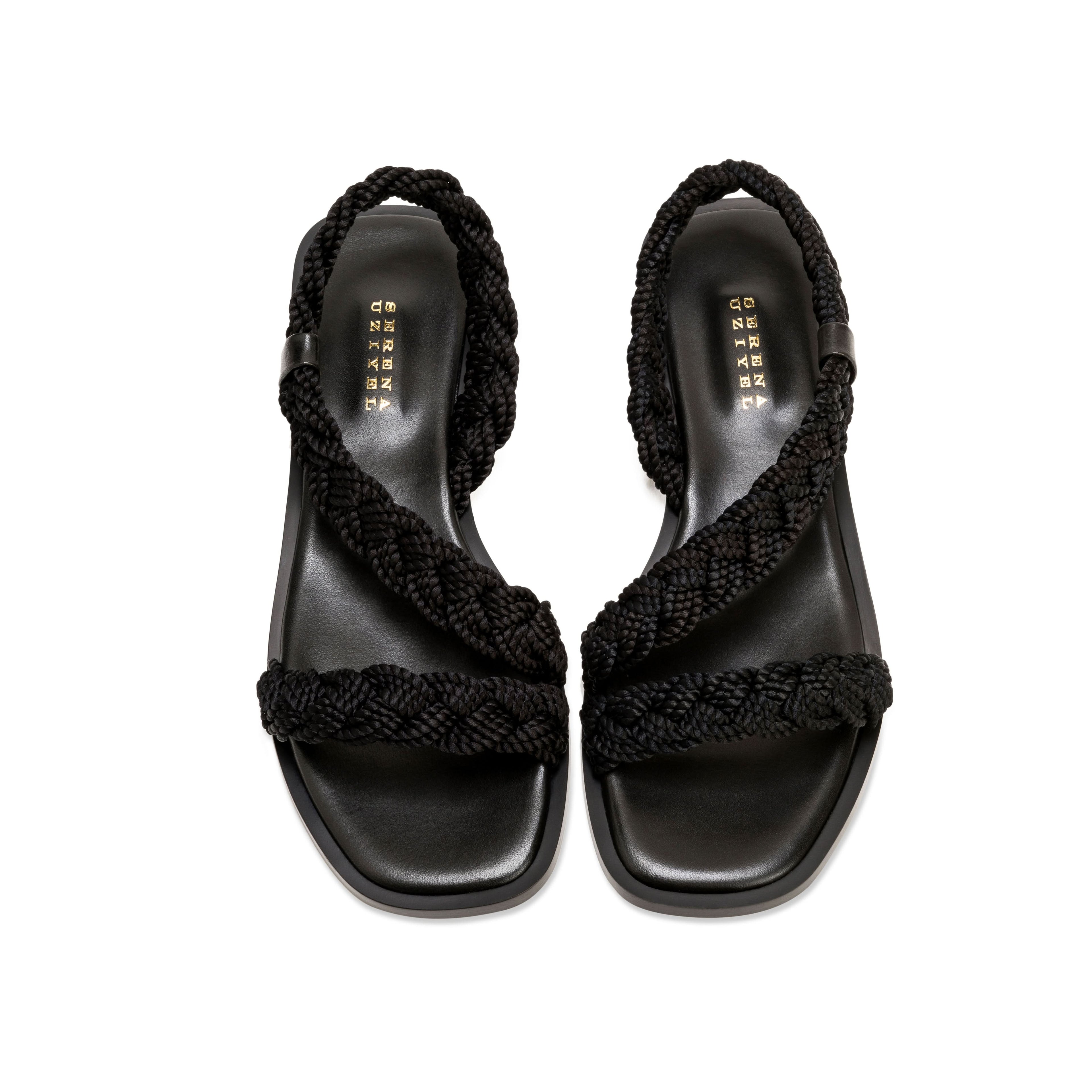 Ronda Black Flat Asymmetric Sandal with braided black straps and sleek leather sole, perfect for summer outings.