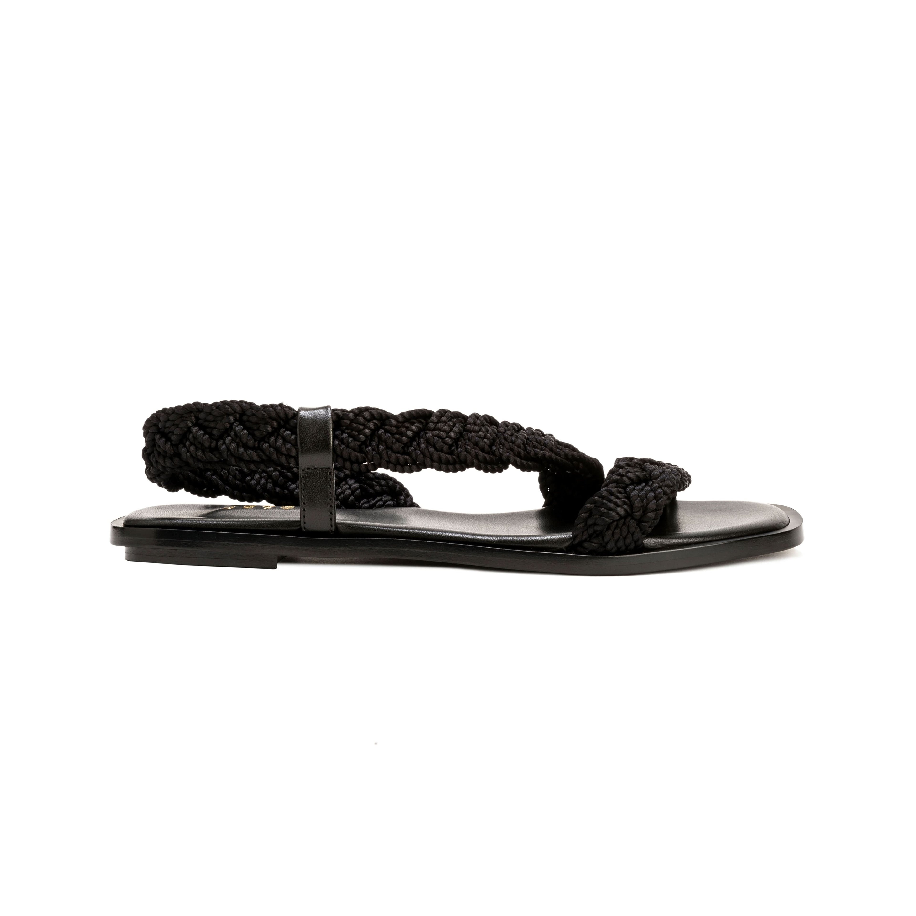 Ronda Black Flat Asymmetric Sandal with braided straps and sleek leather sole, perfect for summer outfits.