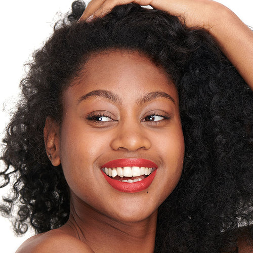 Poppy red shade of the natural and clean Pomponne lipstick on dark skin